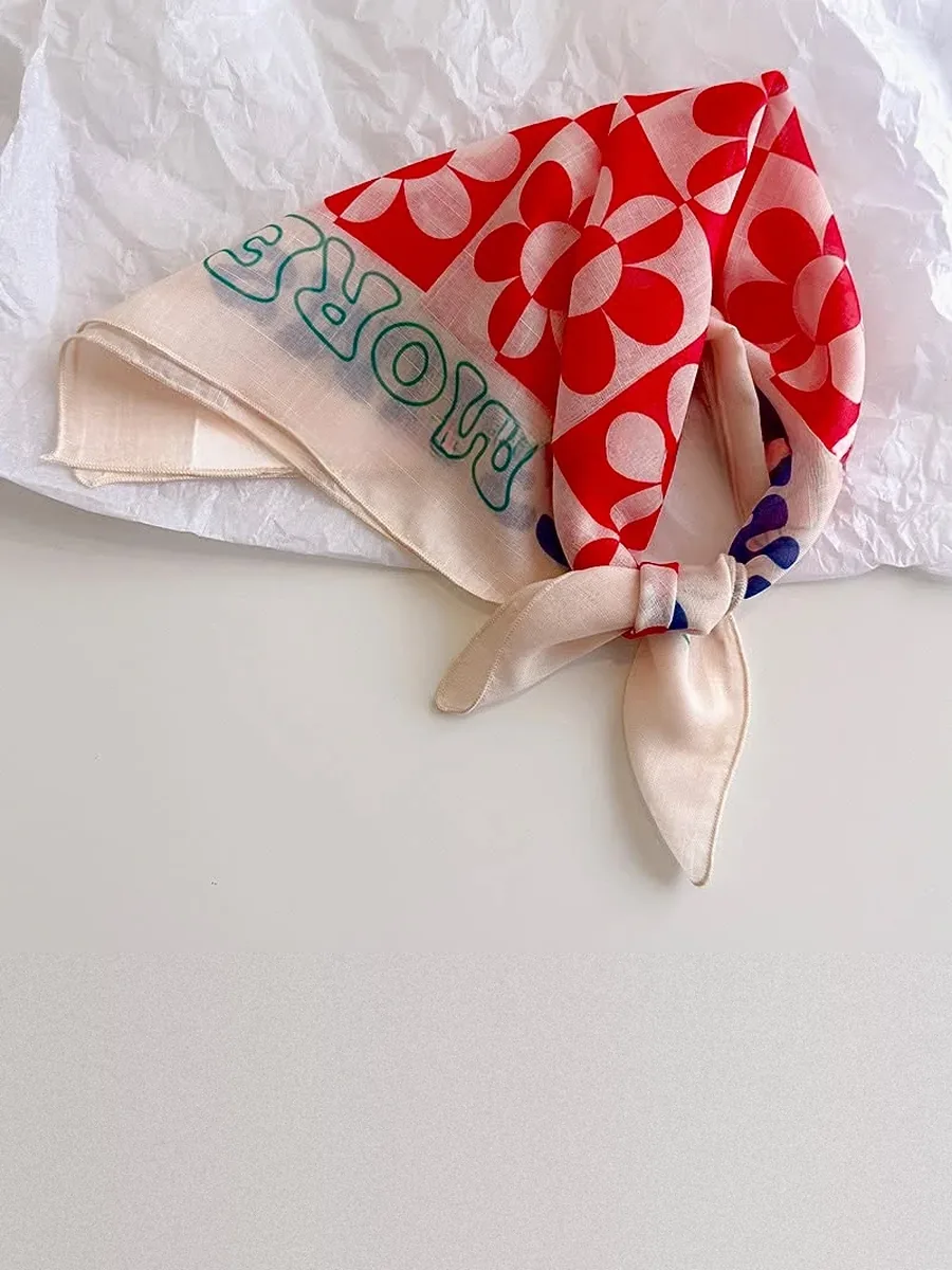 Kinkuu bandana in the red daisy check print, tied and laid flat