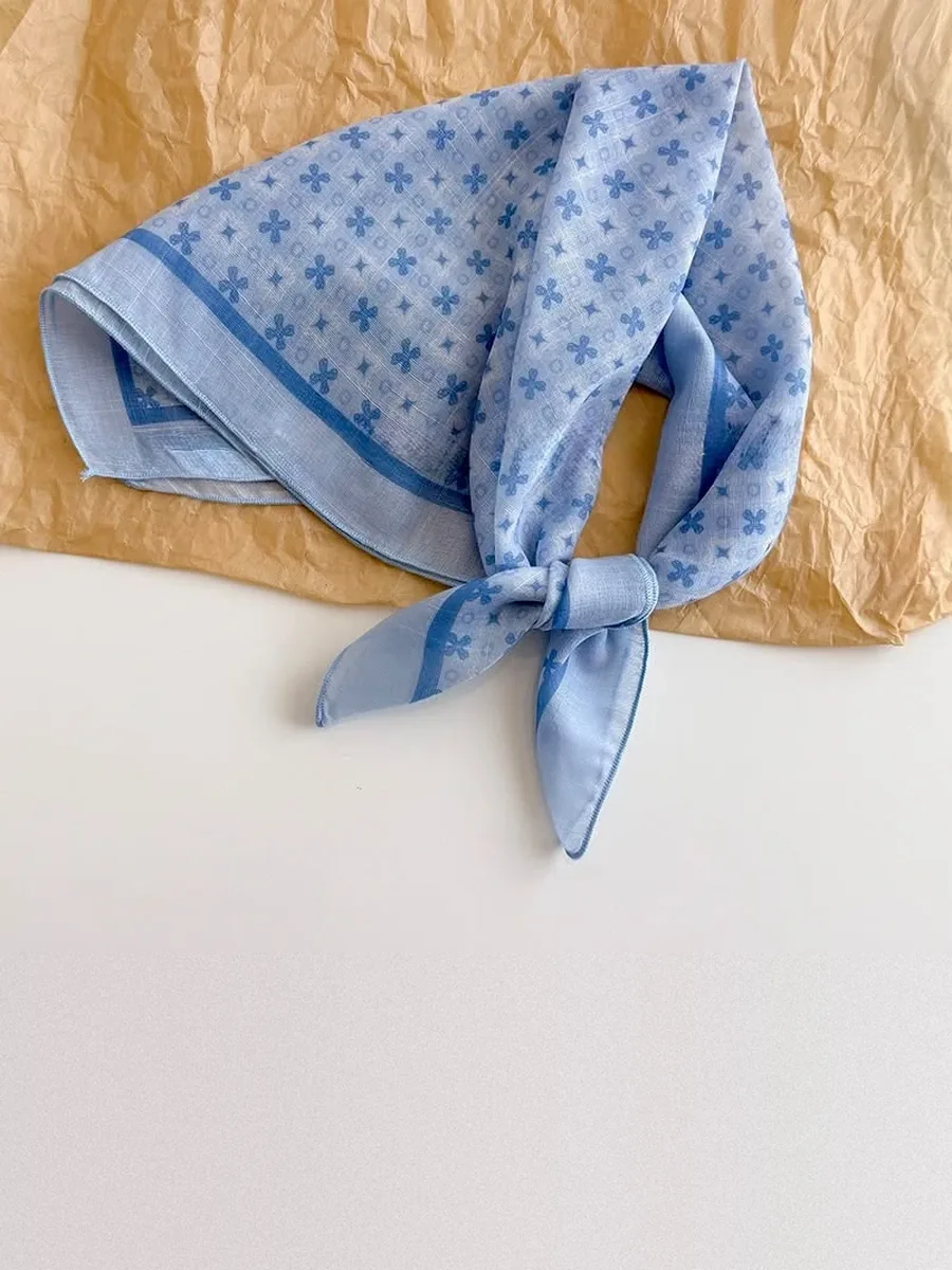 Kinkuu bandana in the sky blue clover print, tied and laid flat