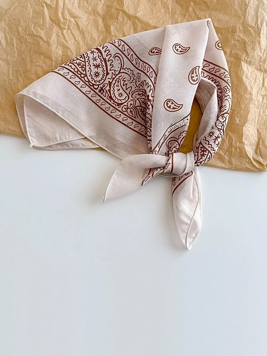 Kinkuu bandana in the cream paisley print, tied and laid flat