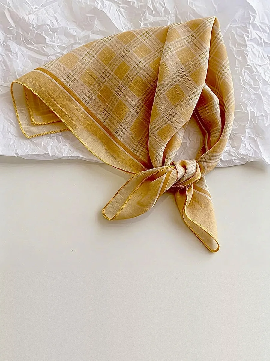 Kinkuu bandana in the mustard check print, tied and laid flat