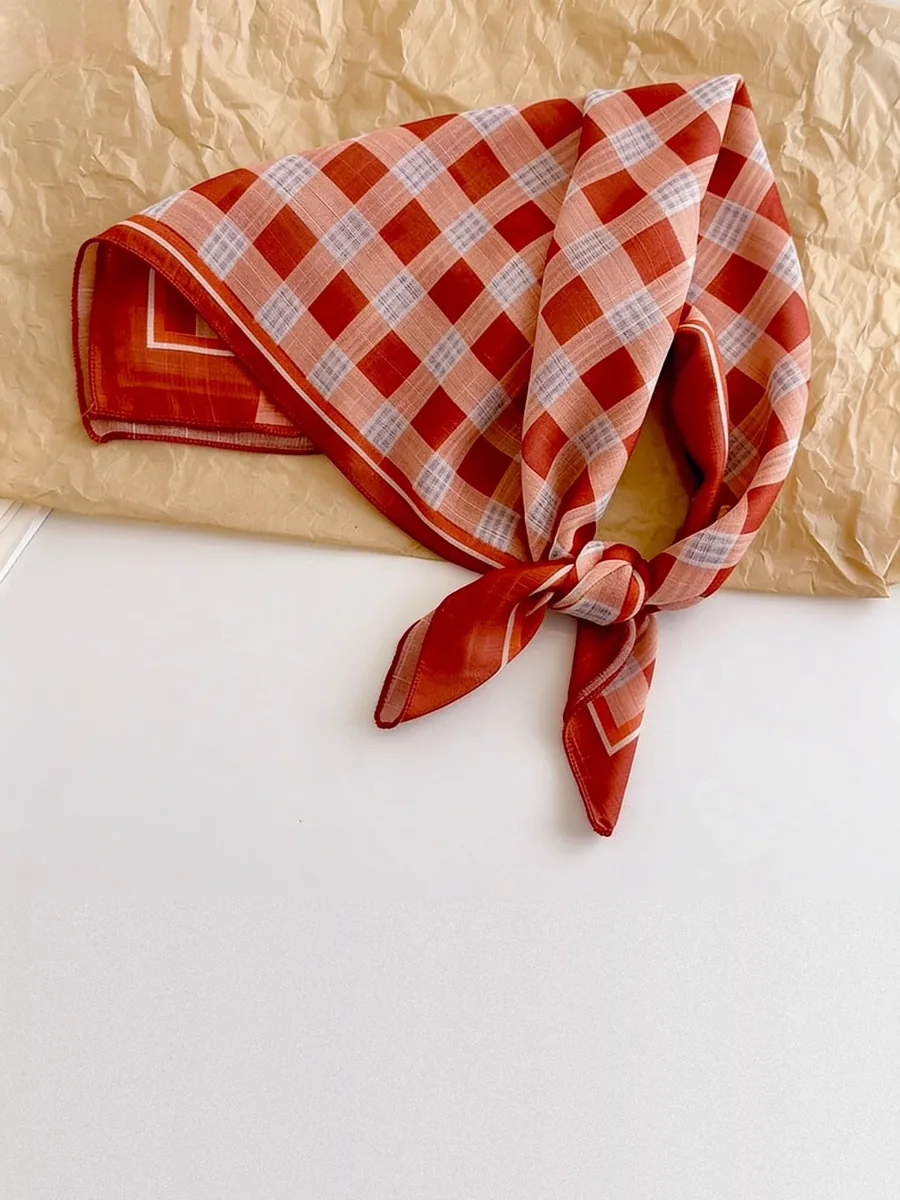 Kinkuu bandana in the rust gingham print, tied and laid flat