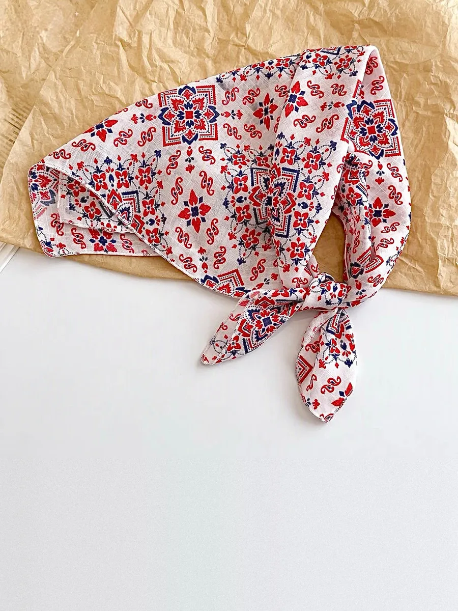 Kinkuu bandana in the red and navy medallion print, tied and laid flat