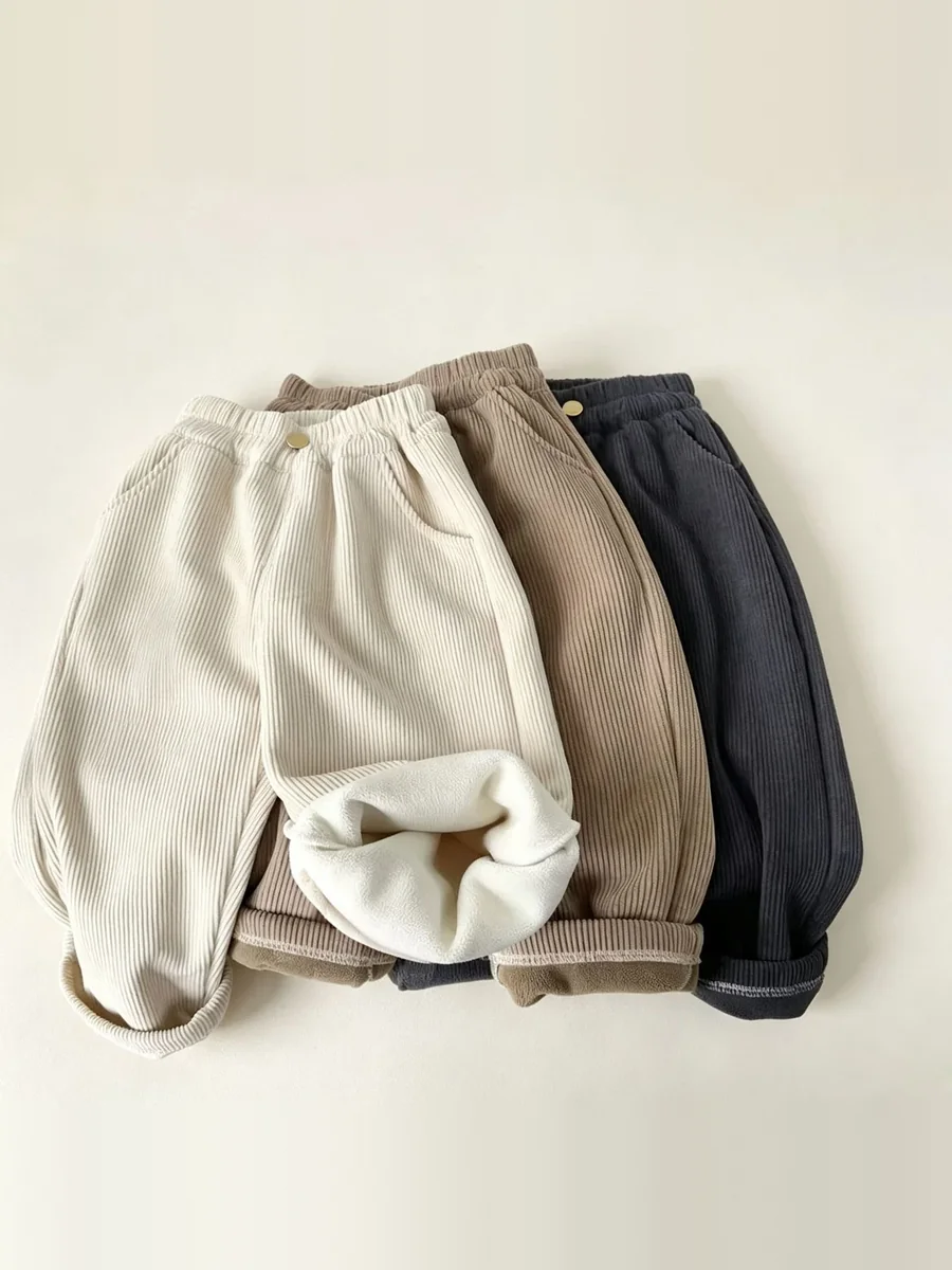 Kinkuu fleece-lined cord trousers bundle: the fleece-lined cord trousers in cream, camel and charcoal laid together, one cuff turned to show the fleece