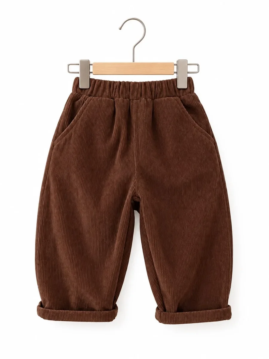 Kinkuu corduroy trousers in chocolate brown, with an elastic waist, side pockets and rolled cuffs, on a hanger