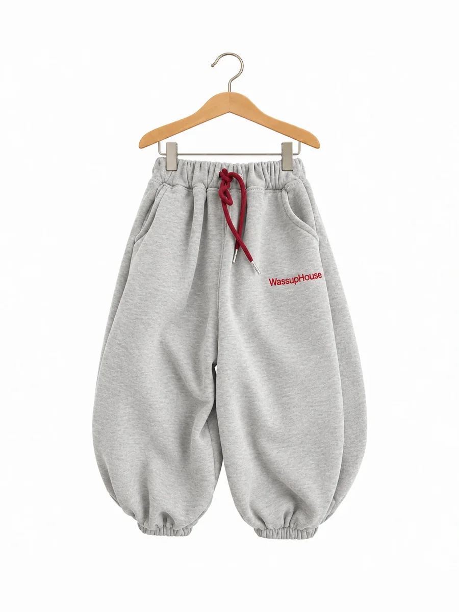 The balloon joggers in grey with a burgundy drawstring, on a hanger
