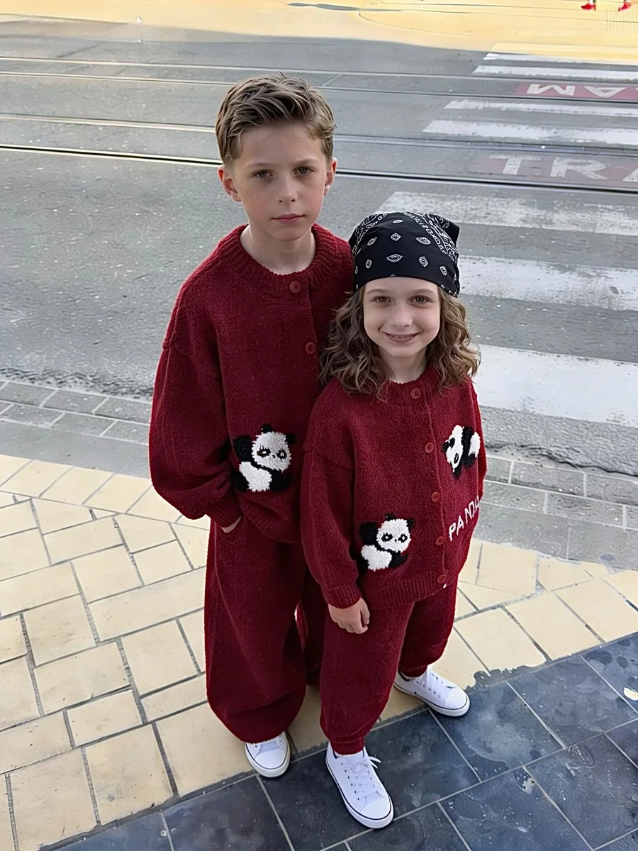 A boy and a girl on a city street, both wearing the cherry red panda co-ord set