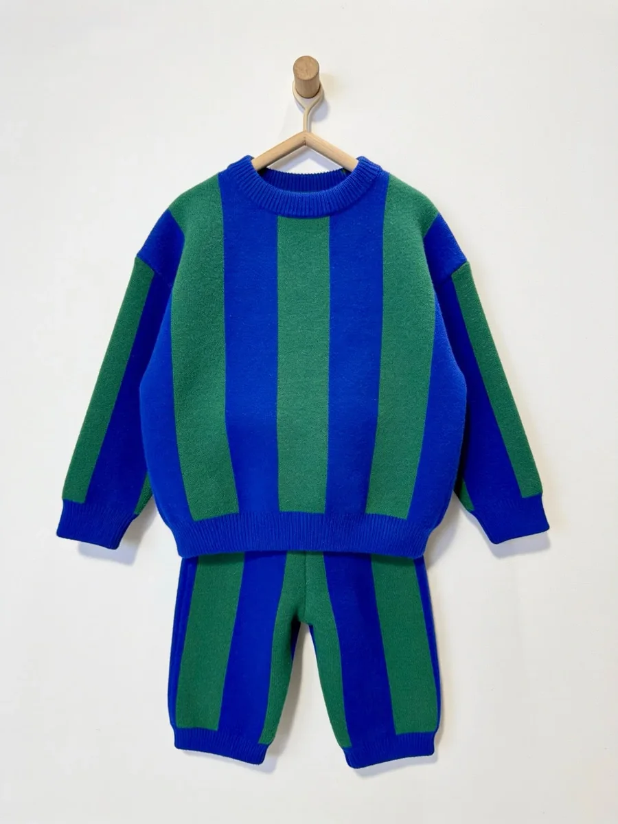 Kinkuu striped co-ord set in blue and green: knit sweater and matching pants on a wooden hanger